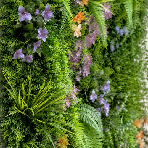 Panneau végétal artificiel Cascade avec lierres, fougères légères et touches florales discrètes.
