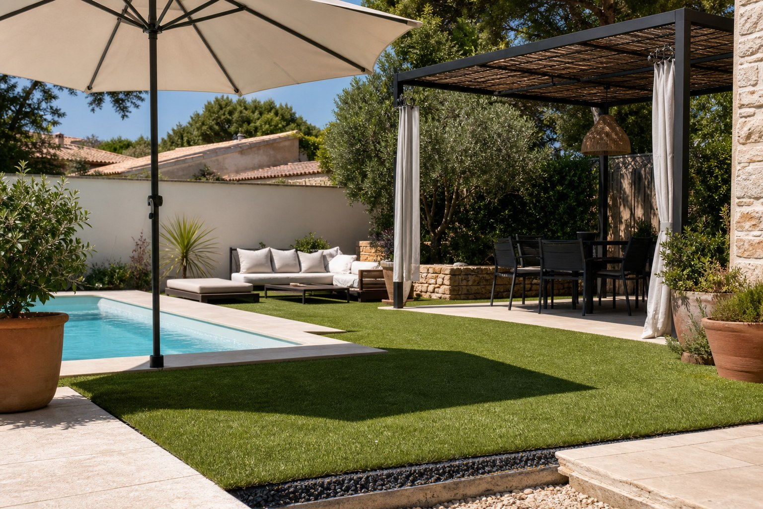 Gazon synthétique autour d’une piscine avec ombrage et préparation drainante visible en bordure